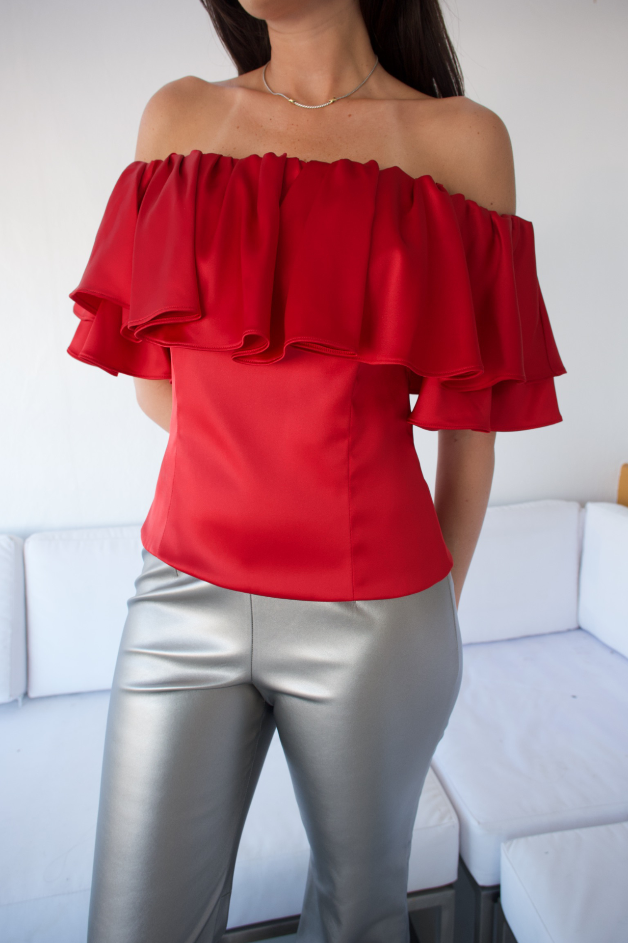 Close-up of the red off-the-shoulder top, highlighting the soft fabric and stylish neckline detail.