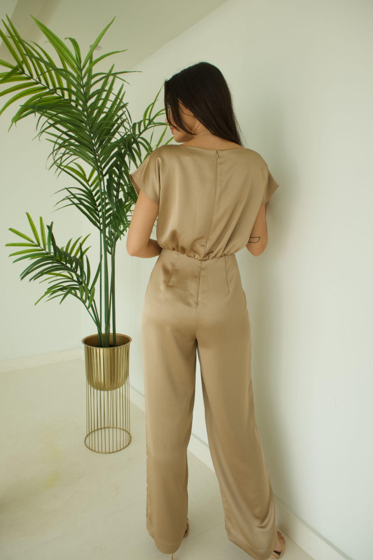 Back view of the Gold Soft Fabric Jumpsuit showcasing its sleek silhouette and flowing soft fabric for effortless sophistication.