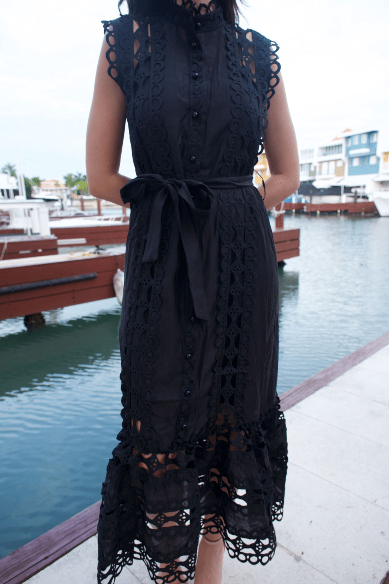 Close-up of a women's black maxi lace trim dress with a belt, highlighting the detailed lace trim and the adjustable belt for a perfectly cinched waist.