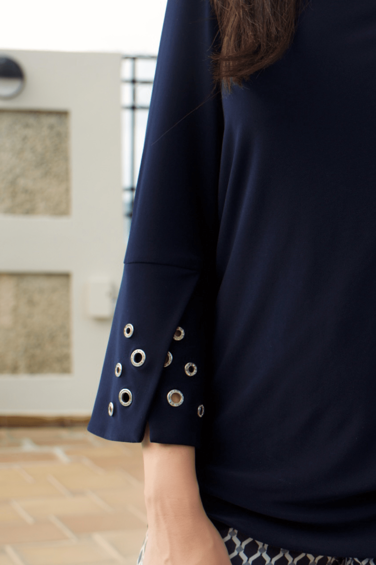 Detailed view of rhinestone circle embellishments on navy top, adding a chic and stylish touch.